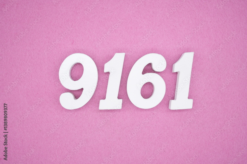 The numbers are made of white painted wood and placed on a pink paper background. The numbers are made of white painted wood and placed on a pink paper background.