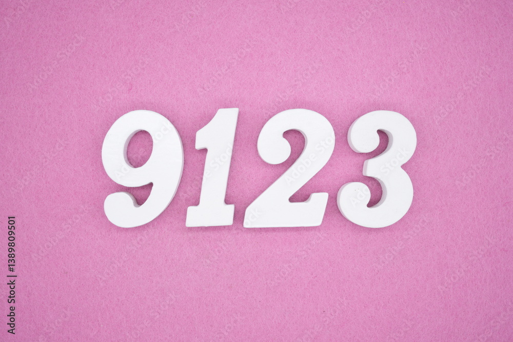 The numbers are made of white painted wood and placed on a pink paper background. The numbers are made of white painted wood and placed on a pink paper background.