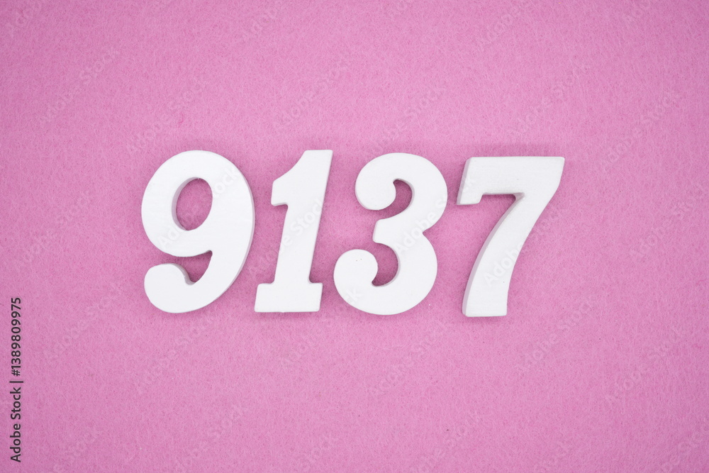 The numbers are made of white painted wood and placed on a pink paper background. The numbers are made of white painted wood and placed on a pink paper background.