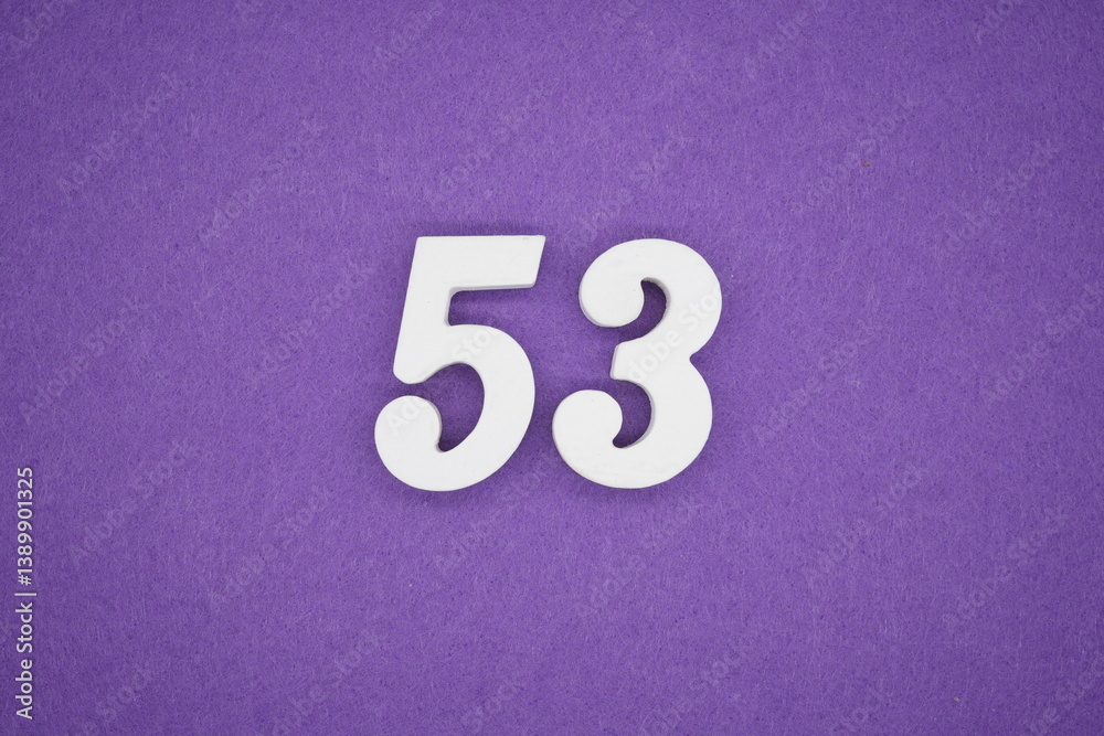 The numbers are made of white painted wood placed on a purple paper background.