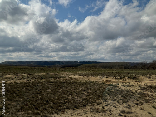 Field with a cloudy sky in the background. The sky is mostly cloudy with some patches of blue