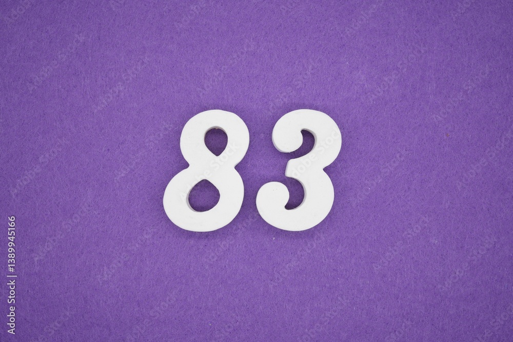 The numbers are made of white painted wood placed on a purple paper background. The numbers are made of white painted wood placed on a purple paper background.