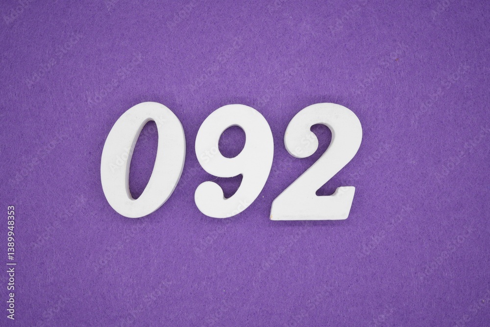 The numbers are made of white painted wood placed on a purple paper background. The numbers are made of white painted wood placed on a purple paper background.