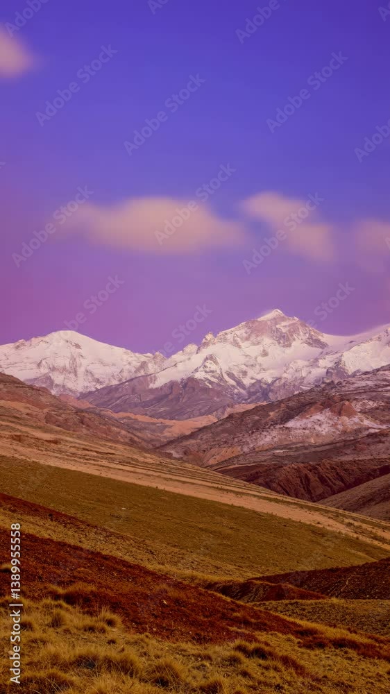 Vertical Video: Majestic Snow-Capped Mountain Peaks at Twilight with Vibrant Colorful Slopes and Grassy Foreground Vertical Video: Majestic Snow-Capped Mountain Peaks at Twilight with Vibrant Colorful Slopes and Grassy Foreground