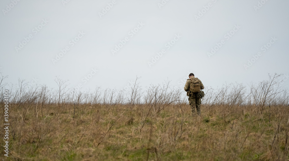 British army soldier tabbing with 25Kg bergen in countryside