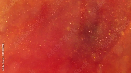 liquid with dissolved particles of red orange candurin and bubbles slowly moves and shines. abstract bright background