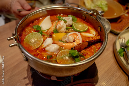Photography A bowl of tomyam soup served in a restaurant using a metal bowl in Bangkok