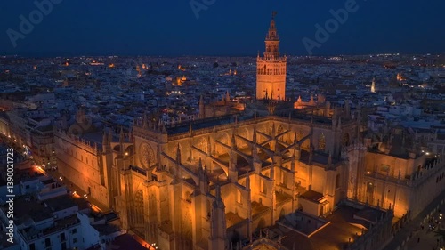 Gothic Cathedral of Seville at Night, Aerial Shot with Giralda bell tower in Seville Old town in Andalusia, Spain.
