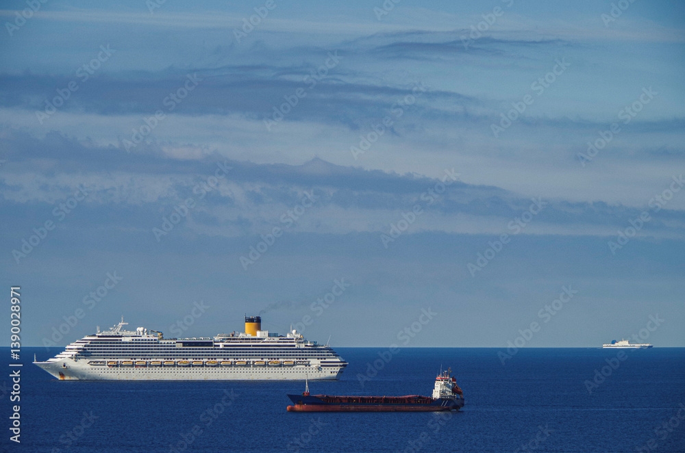 Mega family cruiseship cruise ship liner Favolosa and bunker ship anchored offshore of Civitavecchia Rome, Italy before reactived after Covid pandemic with other vessels in port and coastline
