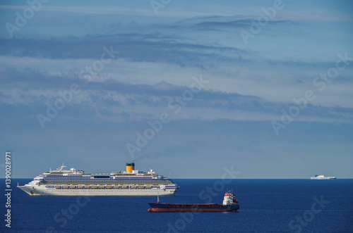 Obraz na płótnie Mega family cruiseship cruise ship liner Favolosa and bunker ship anchored offshore of Civitavecchia Rome, Italy before reactived after Covid pandemic with other vessels in port and coastline w salonie