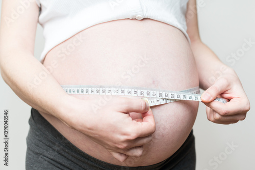 Εκτύπωση καμβά belly size during pregnancy, a woman measures her belly circumference in the nin