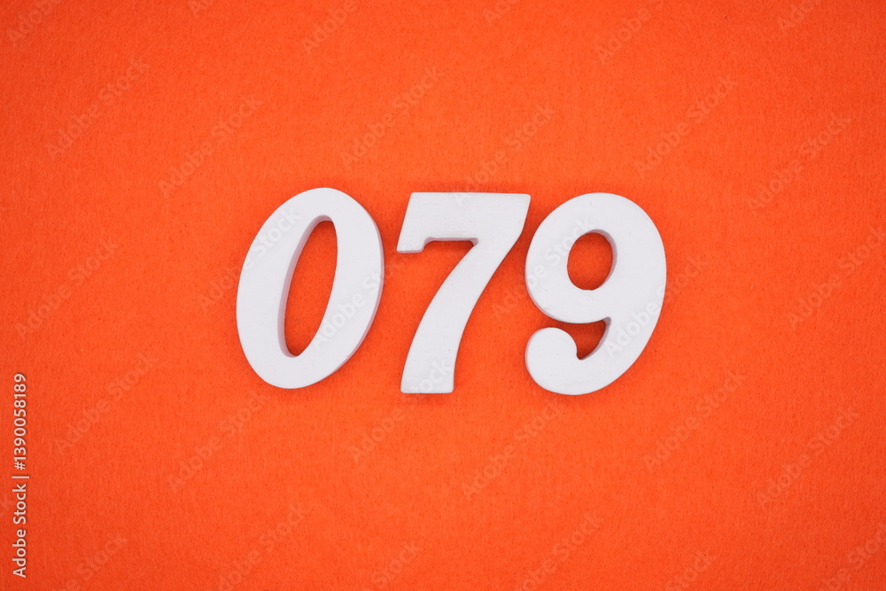 The numbers are made of white painted wood placed on an orange paper background. The numbers are made of white painted wood placed on an orange paper background.
