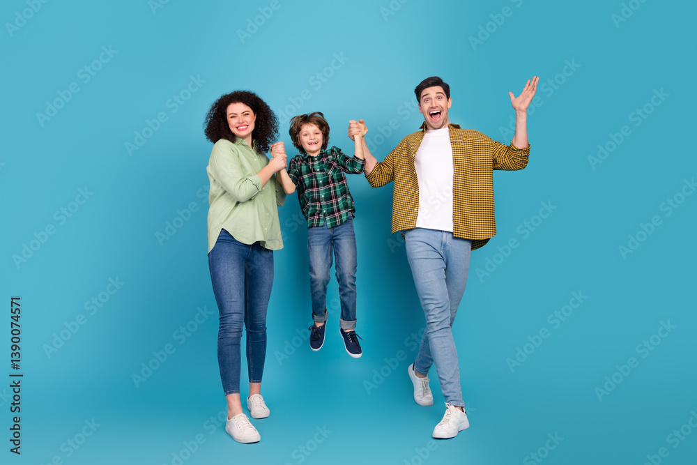 Fototapeta premium Happy family enjoying quality time, parents holding their child in a joyful pose against a vibrant blue background