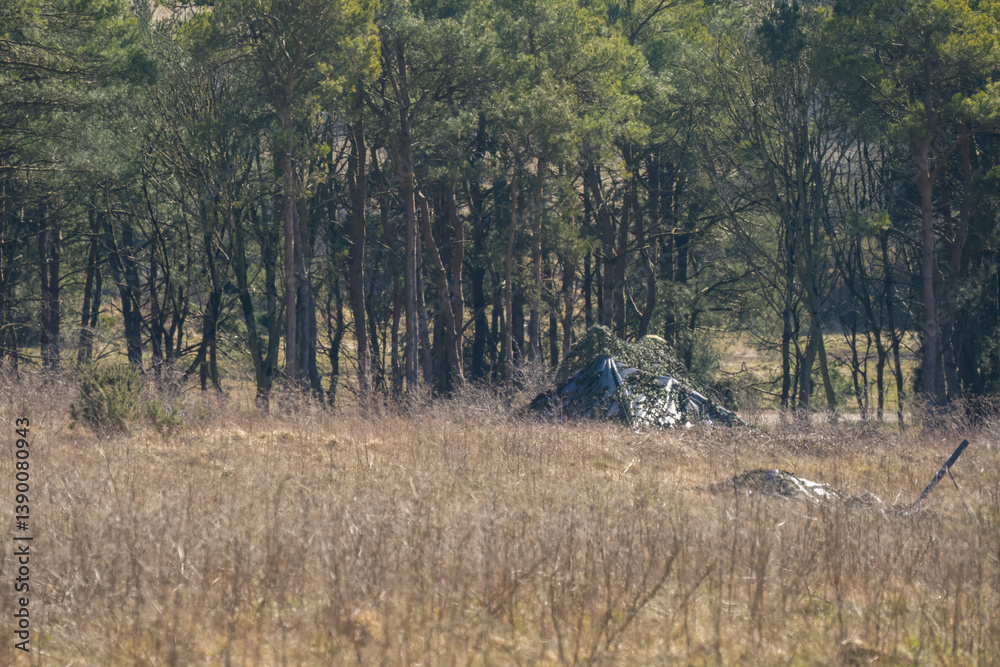 army camouflage netting cover deployed to hide broadcast equipment