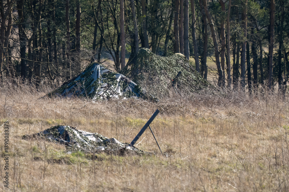 army camouflage netting cover deployed to hide broadcast equipment
