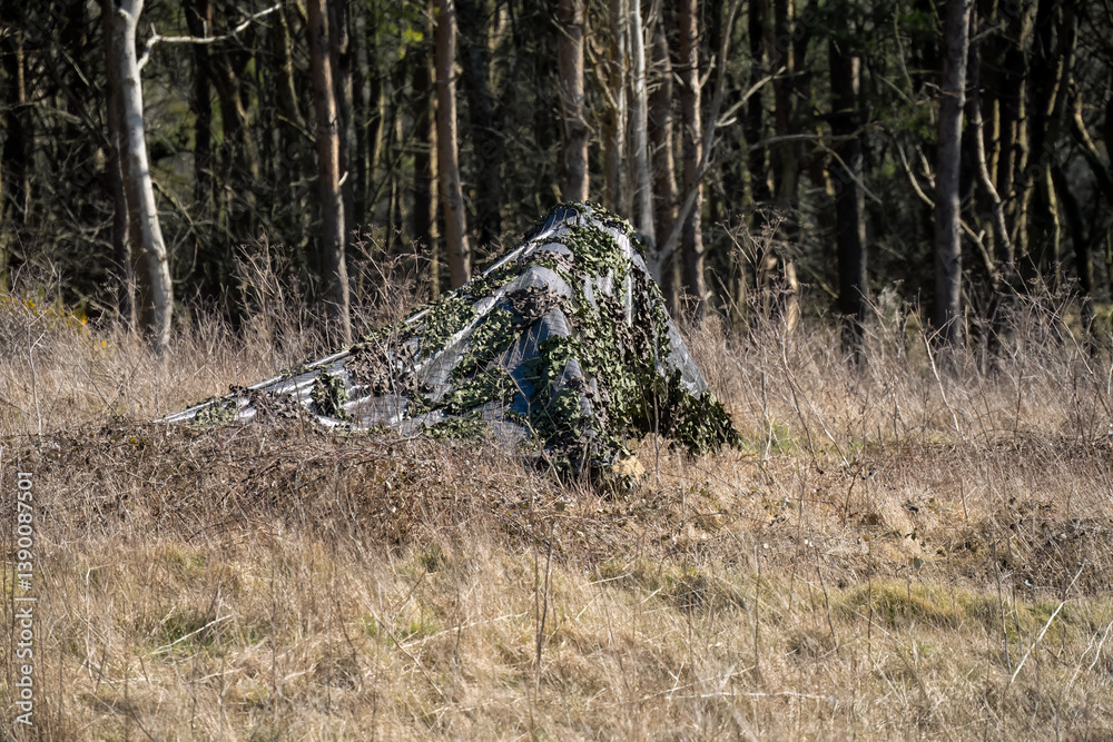 army camouflage netting cover deployed to hide broadcast equipment