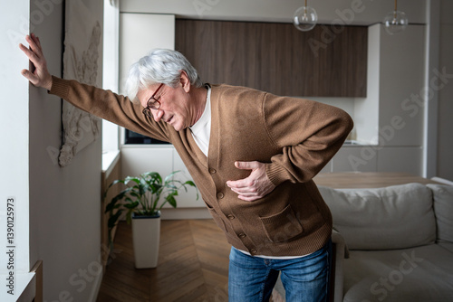 Afflicted senior man feel severe retrosternal pain with breathing difficulty, gripping chest. Myocardial ischemia, coronary insufficiency, radiating arm pain, autonomic symptoms, emergency pain