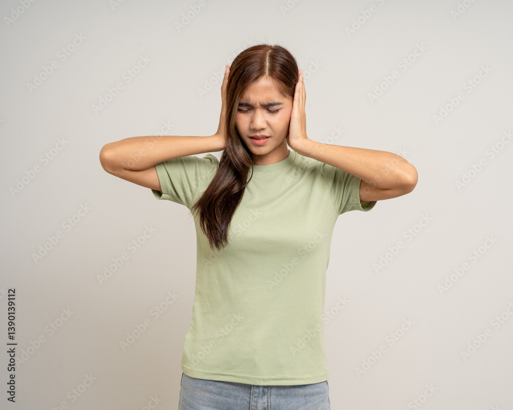 Young Woman stressed and frustrated covering her ears with her hands due to loud noise. Annoyed noise sound pollution. Asian Woman blocking ears Young Woman stressed and frustrated covering her ears with her hands due to loud noise. Annoyed noise sound pollution. Asian Woman blocking ears