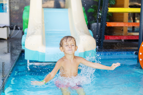 Obraz na płótnie Boy splashing in pool from water slide w salonie