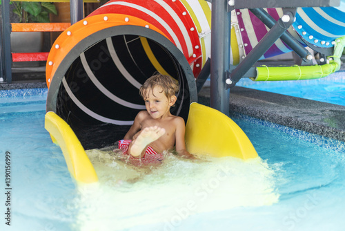 Child on colorful water slide exit
