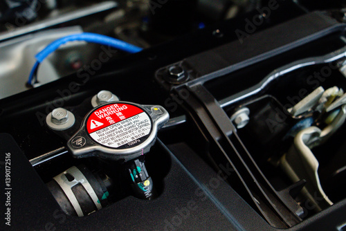 Car radiator cap in the engine room. Radiator cap with warning label in a car engine. car maintenance and repair concept. components of car concept.
