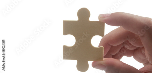 Hand holding puzzle piece close-up conceptual image minimalist background focus on problem solving