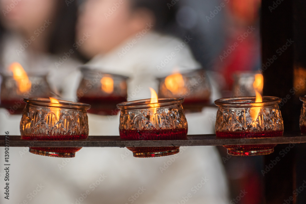 Burning glass of candles in the buddhism temple