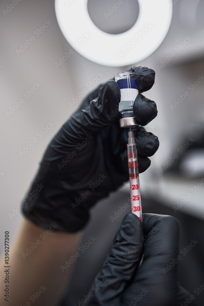 Gloved hands filling syringe with medicine, precise dosage preparation in lab setting, healthcare application concept