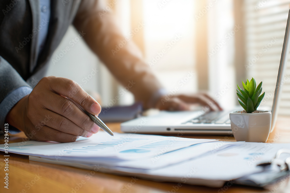 A person in business attire is writing on a document with a pen and paper on a desk. A person in business attire is writing on a document with a pen and paper on a desk.