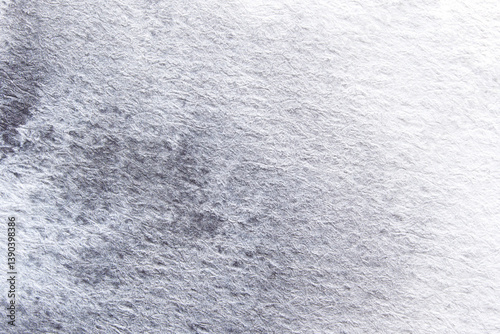 Close-up of textured grey paper surface with subtle variations and abstract patterns.