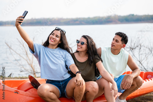 Group of latin hispanic friends having fun taking a selfie by the lake ready to go kayaking at summer