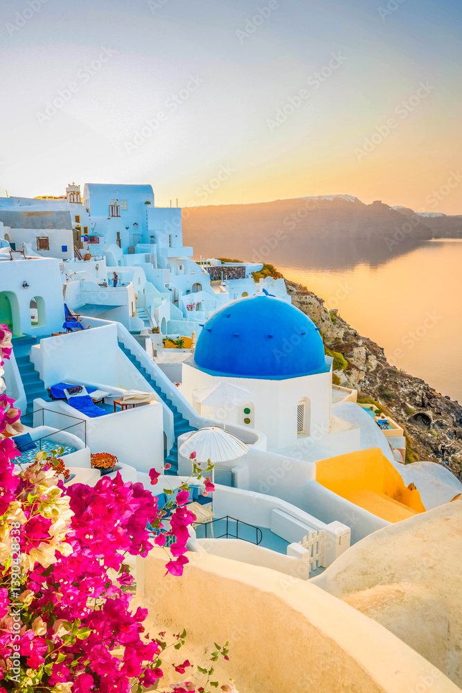 Naklejka premium traditional greek village Oia of Santorini, with blue domes of churches and village roofs, Greece
