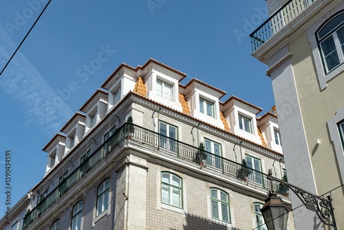 Exterior of an apartment building with balconies against a blue sky 