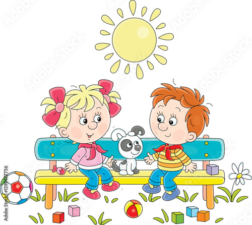 Happy little children with a puppy on a bench in a park