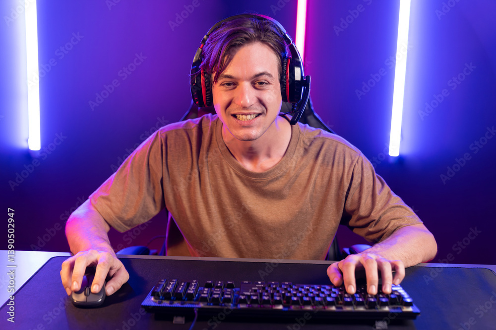 Host channel of gaming smart streamer playing online game to be winner, wearing headphone with viewers live steaming on media social online for selected team competition at neon light room. Pecuniary. Host channel of gaming smart streamer playing online game to be winner, wearing headphone with viewers live steaming on media social online for selected team competition at neon light room. Pecuniary.