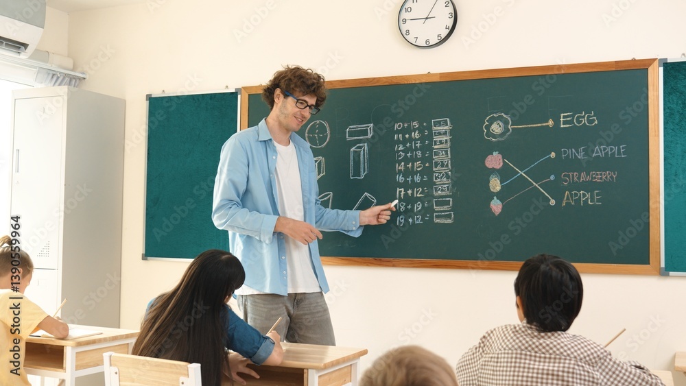 Caucasian teacher talking and explain about math theory at classroom while looking at student. Smart skilled instructor teaching and pointing at blackboard while standing in front of board. Pedagogy.