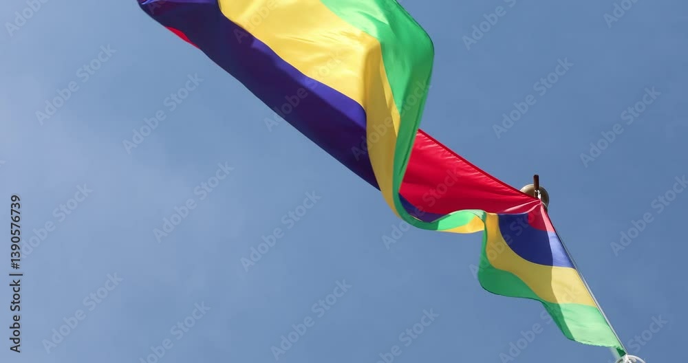 Mauritius National Flag fluttering in the wind. Great for news. Close-up. Mauritius flag against blue sky. 4K video.