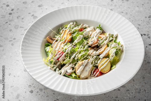 Photos A fresh salad featuring a mix of greens, cherry tomatoes, and shredded vegetables, drizzled with creamy dressing, elegantly arranged in a textured white bowl