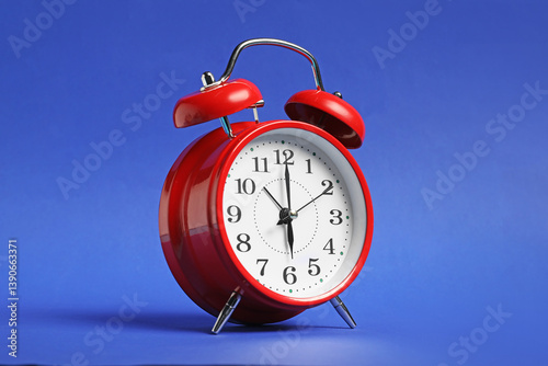 One red alarm clock on blue background