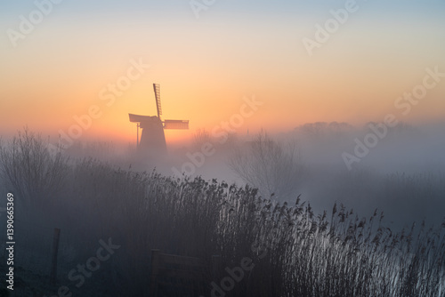 Obraz na płótnie Dawn at a traditional, Dutch windmill in the spring fog. w salonie