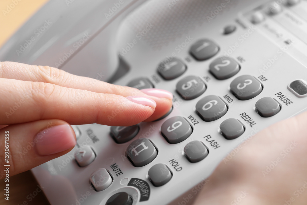 Woman dialing number on landline telephone, closeup Woman dialing number on landline telephone, closeup