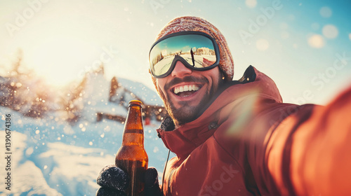 A smiling man in sports gear snowboards while holding a beer bottle, set against a snowy and bright sky photo