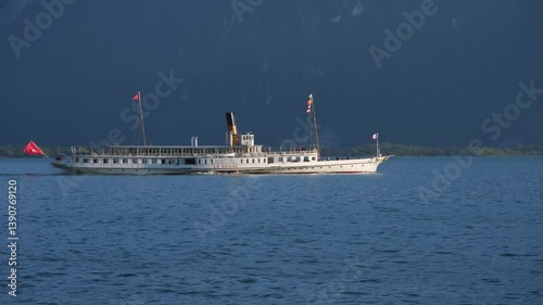 Montreux, Switzerland - May, 30 2019: Beautiful summer evening landscape of Lake Geneva with picturesque shores and pleasure ship against the backdrop of the green slopes of the Alps, Switzerland. 4K 