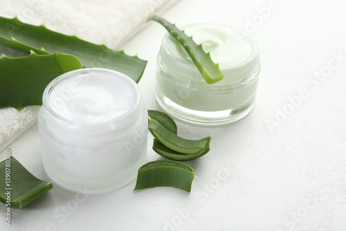Obraz na płótnie Moisturizing cream with extract of aloe vera, cut leaves and towel on white textured background, closeup w salonie