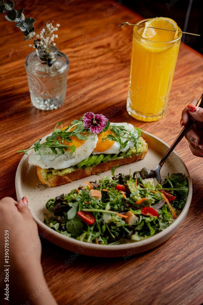 Avocado Toast with Fried Egg and Edible Flowers on Rustic Table Avocado Toast with Fried Egg and Edible Flowers on Rustic Table