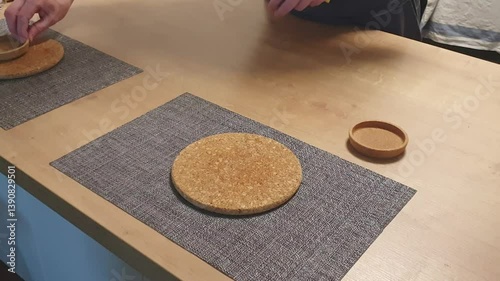 Person wipes kitchen table surface. Chores