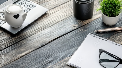 Simple workspace with laptop, teapot, notepad, and accessories