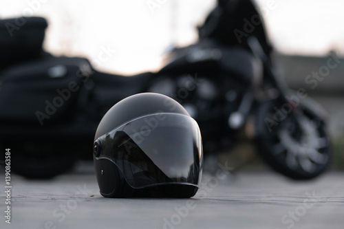 A stylish black motorcycle helmet is showcased in the foreground with a blurred motorcycle in the background, perfect for capturing the essence of adventure and safety.