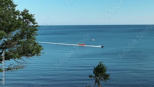 A motor boat carries happy people on an inflatable banana along the Black Sea. Krasnodar region. Vacation, relaxation, entertainment.