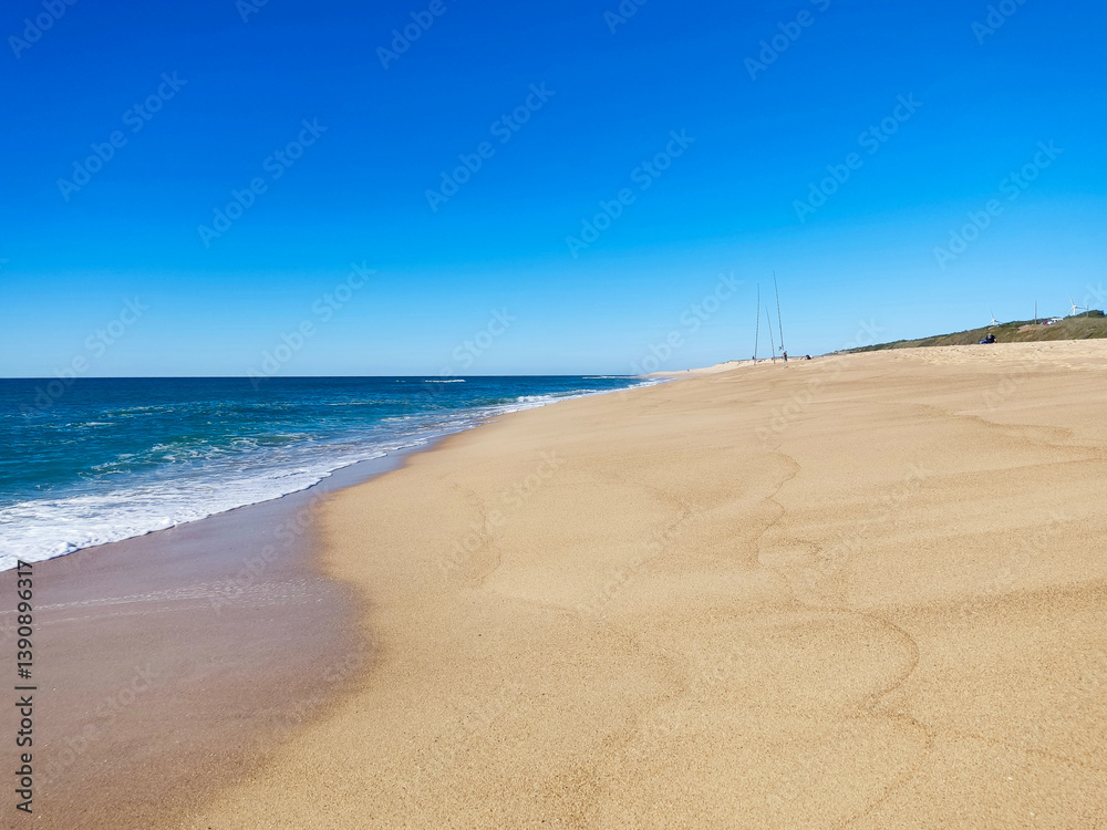 Serene coastal vista. Golden sand meets turquoise water under a clear blue sky. Symbolizes tranquility, vacation, and natural beauty. Ideal for travel or lifestyle themes. Serene coastal vista. Golden sand meets turquoise water under a clear blue sky. Symbolizes tranquility, vacation, and natural beauty. Ideal for travel or lifestyle themes.